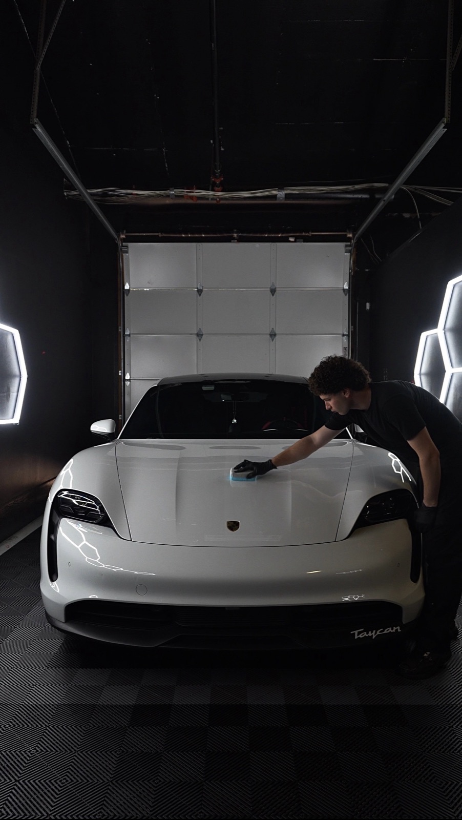 Regency Auto Protection technician hand-polishing a Porsche Taycan